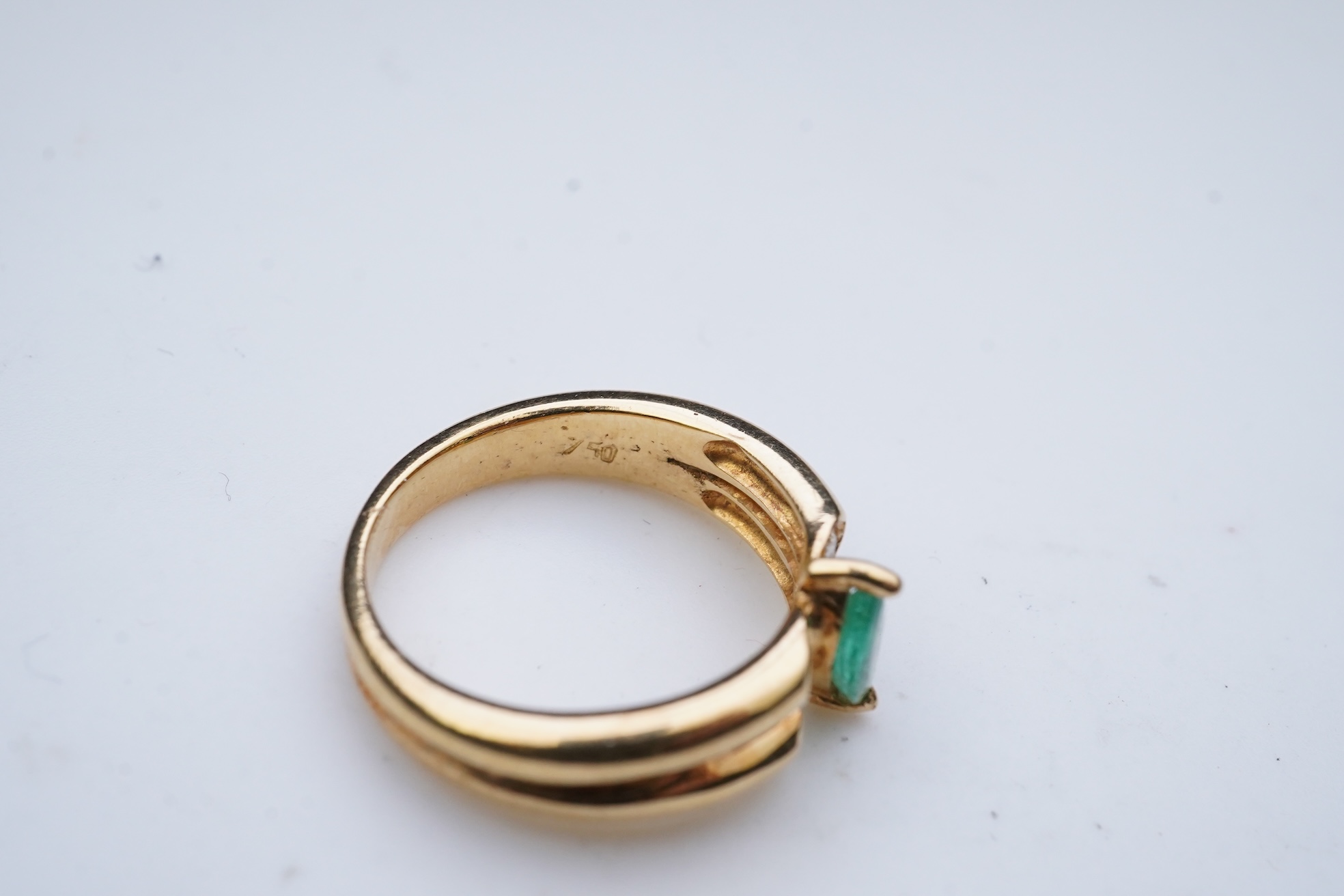 An emerald and diamond ring